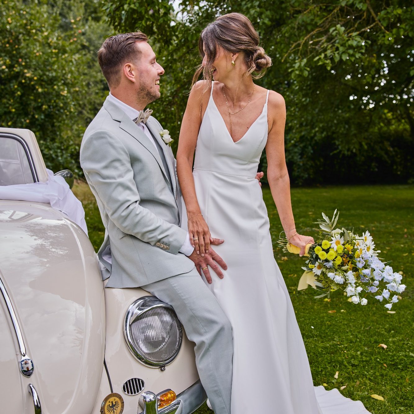 Paarshooting am Oldtimer auf dem Uphof Natürliches Paarfoto neben einem Oldtimer während der Hochzeit auf dem Uphof in Bielefeld aufgenommen von der Hochzeitsfotografin Selina