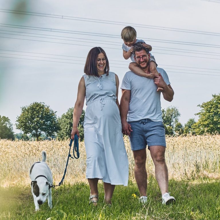 Fotografie von glücklicher Familie mit Kind und Hund